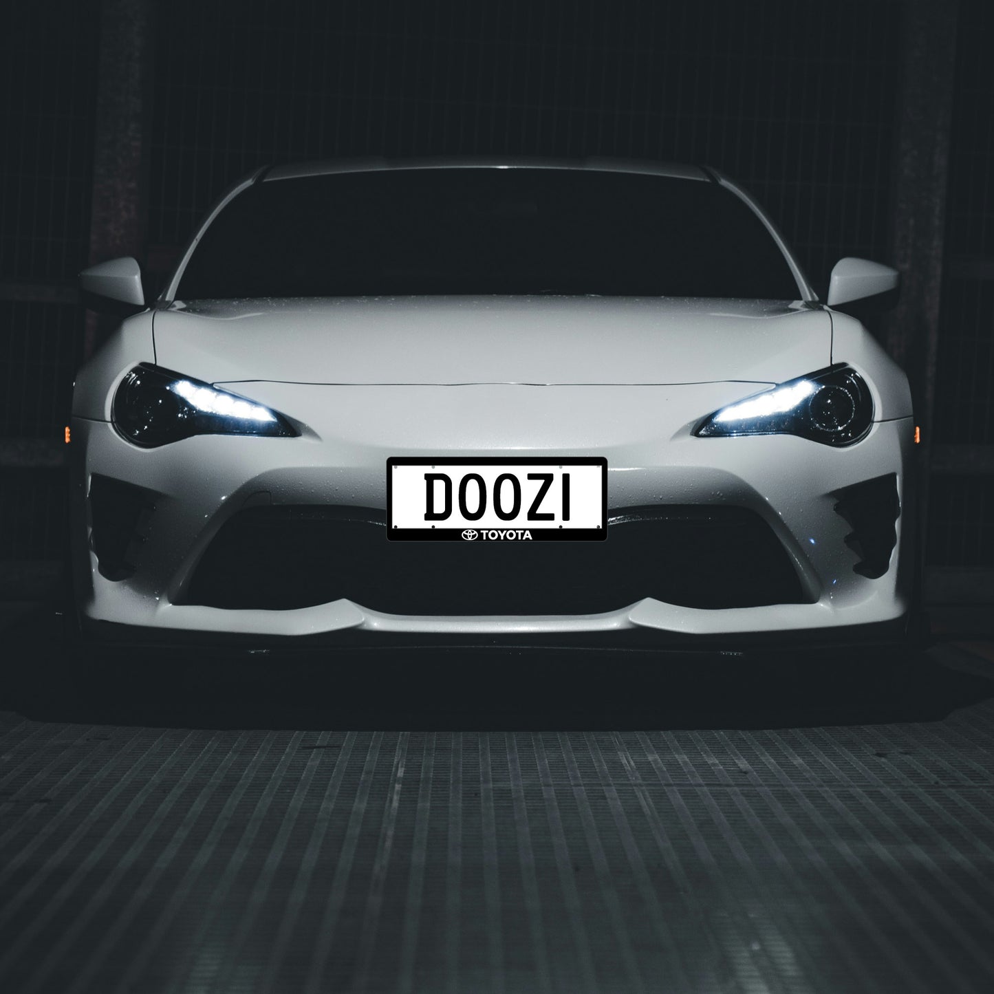Automotive branded number plate surrounds